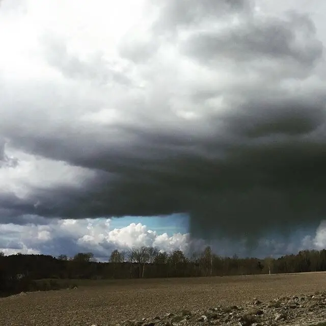 En åker med väldigt mörka moln över.
