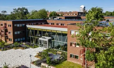 Bild på en stor tegelbyggnad under en somrig dag med en vinkel ovanifrån.