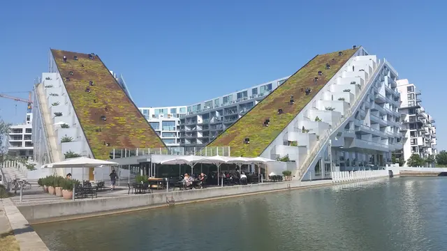 The 8House in Copenhagen, winner of the Scandinavian Green Roof Award in 2010. Sedum roofs and the large pond strengthen the strong character of the building.