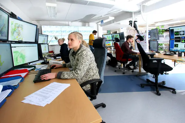 Meteorologer som sitter framför datorer i ett kontor.