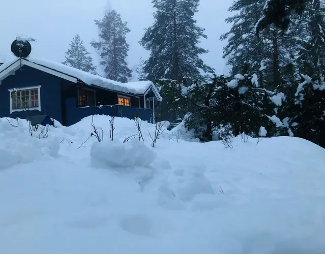 Stora mängder snö vid en röd stuga i Södra Hälsingland.