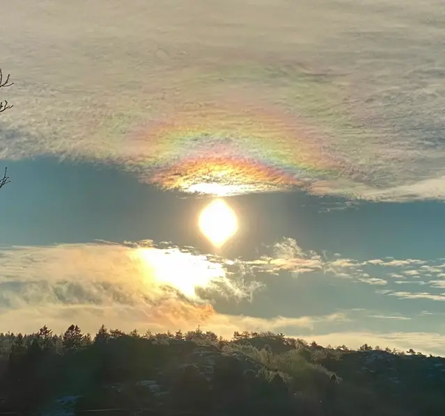 Bilden visar ett kransfenomen i ett altocumulustäcke kring solen.