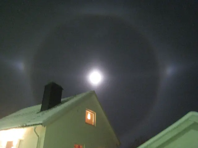 En måne över takåsarna med en halo och två bimånar.