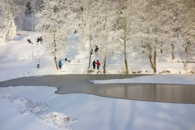 Människor vid en sjö där isen håller på att lägga sig.